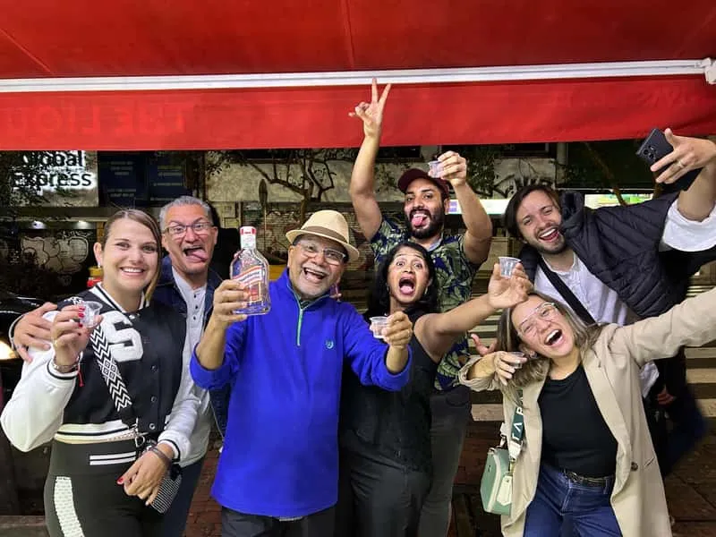 Group of travelers enjoying VIP pub crawl through rooftop bars and nightclubs in El Poblado on a Medellin Colombia nightlife tour