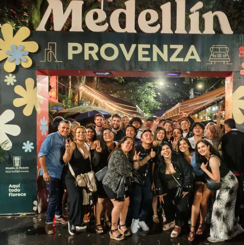 Tourists on a rooftop bar in El Poblado with city views during a Medellin Colombia nightlife clubs guided tour