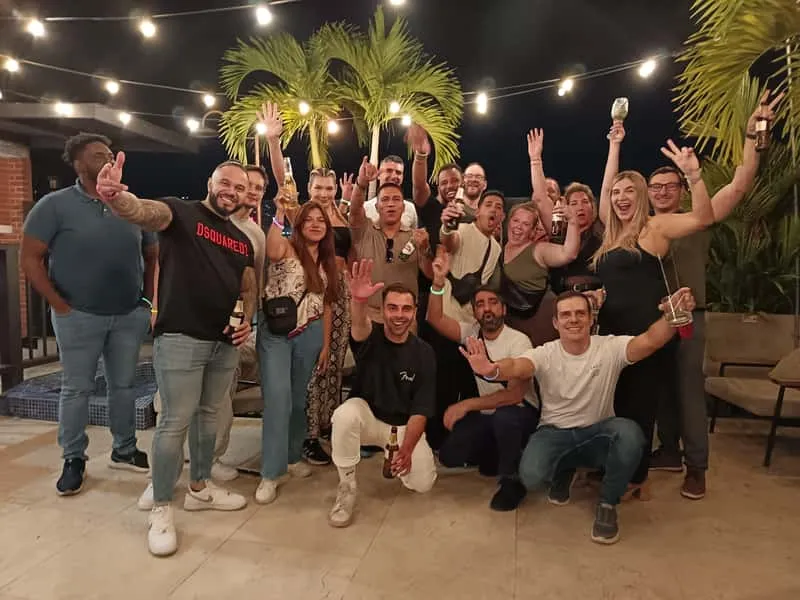 Small group of tourists with a bilingual guide entering a local rooftop nightclub on a Medellin Colombia nightlife tour